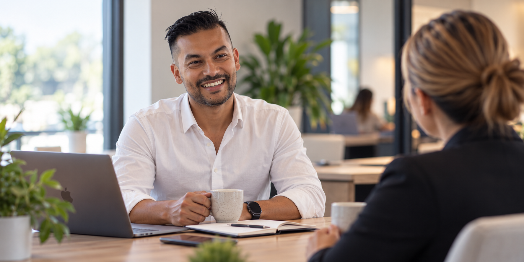 Eddie Freitas in conversation with a client at a table in a bright office